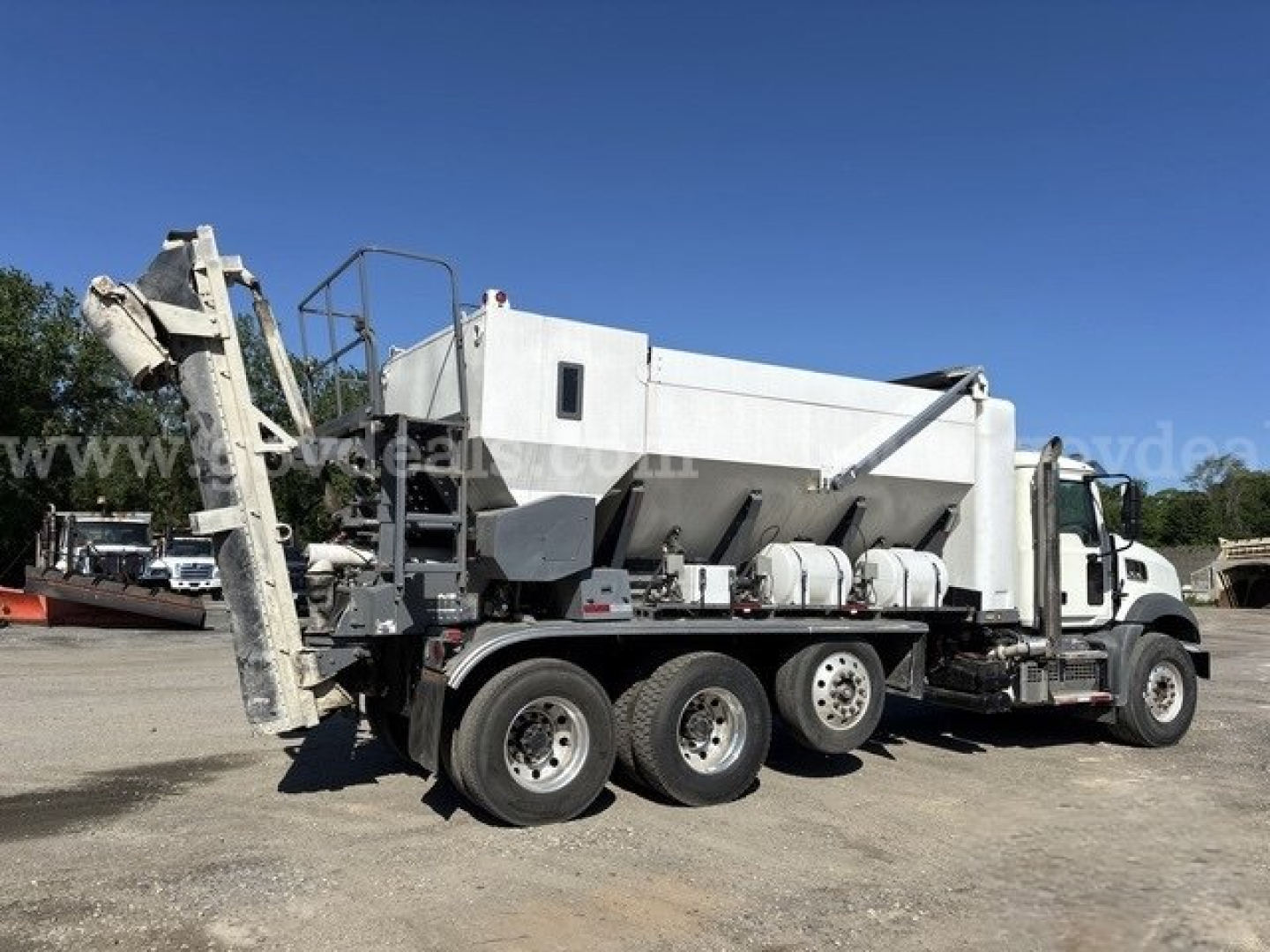 Truck bed mixer body of a Freightliner 114SD with concrete mixer drum and chute, side view showing dual rear axles and white cab.