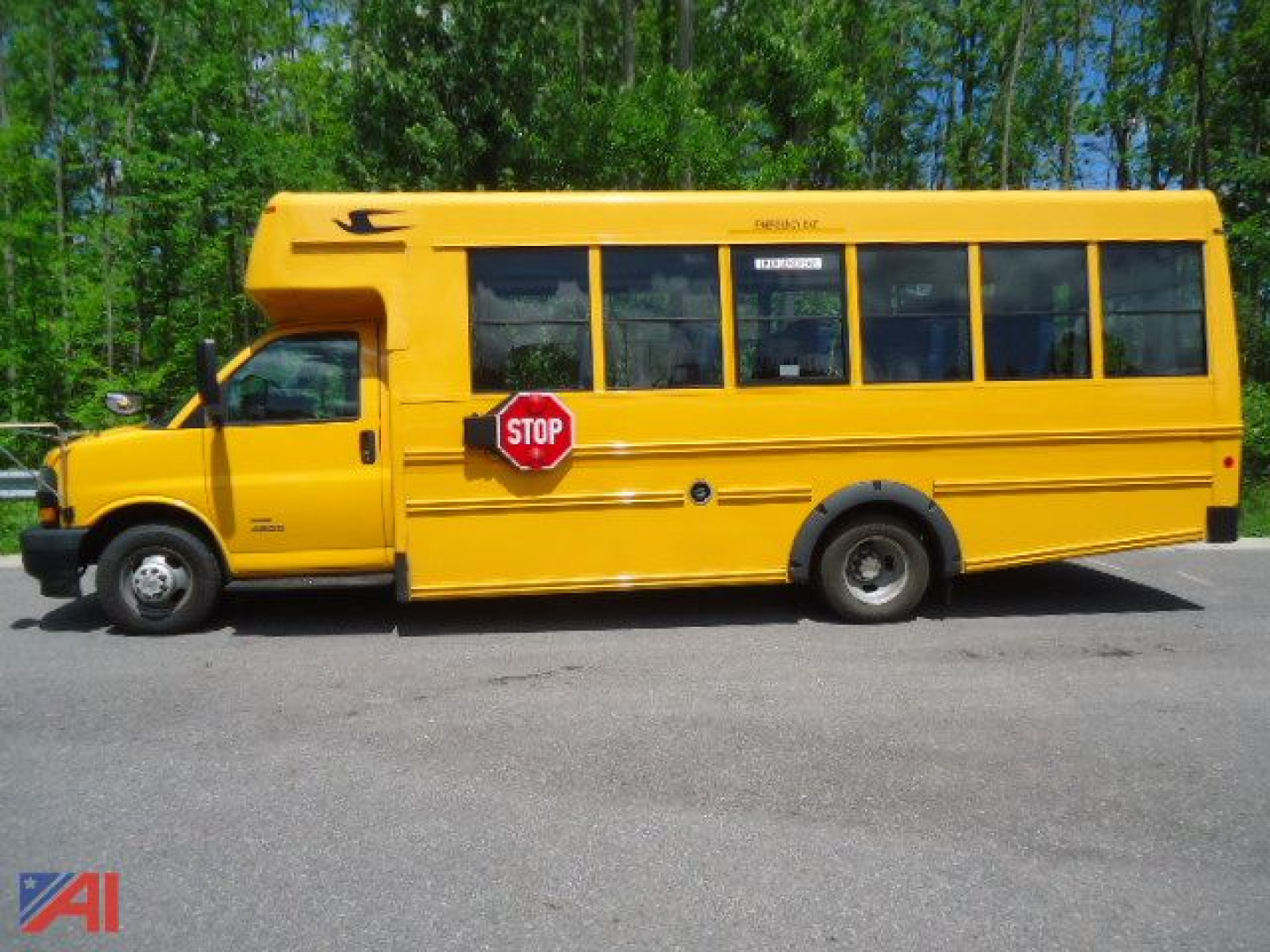 School bus side view showing a yellow 2020 Chevrolet Express 4500 Micro Bird with stop sign extended, black trim, and multiple windows.