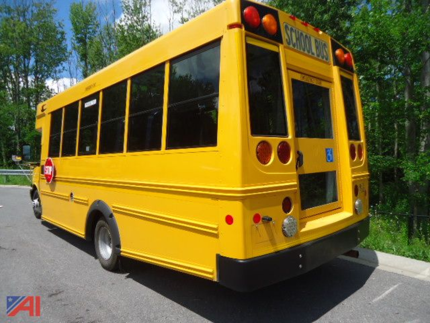 Rear and side view of a yellow 2020 Chevrolet Express 4500 Micro Bird school bus, with black bumper, wheelchair-accessible rear door, and 'School Bus' sign on top rear.