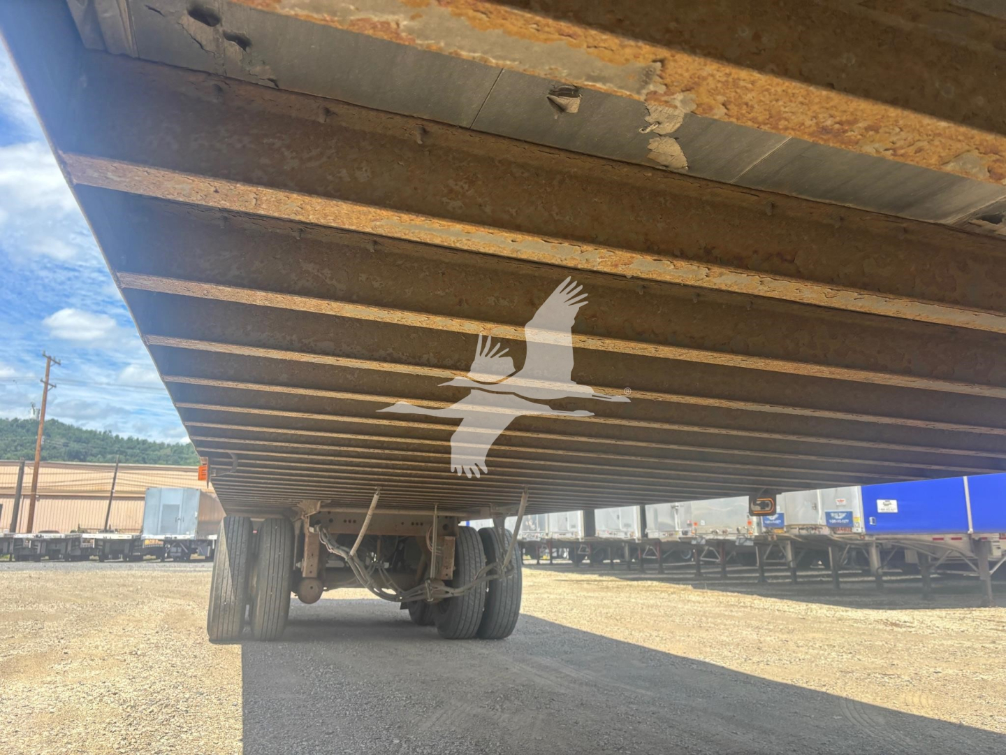 Trailer underside view showing frame rails and suspension with dual rear wheels; Vanguard VXP trailer undercarriage details visible.