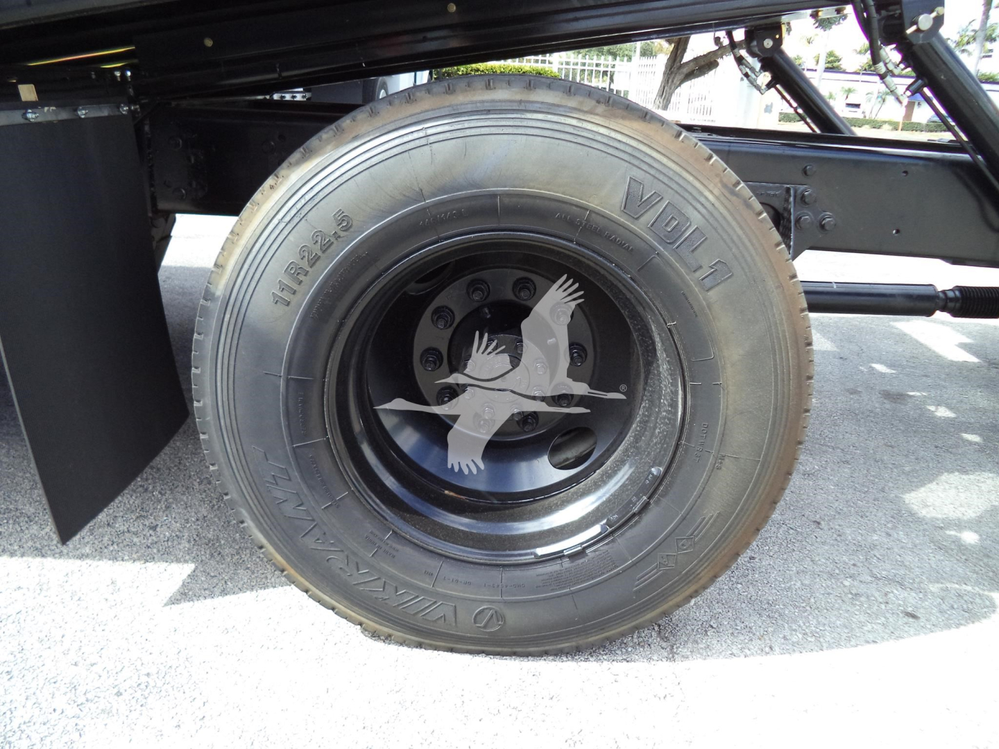 Back/side view of a wheel on a 2019 International 4300 rollback truck showing a VDL 10R22.5 tire and a decorative white goose emblem on the wheel.