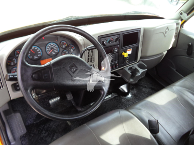 Dashboard and steering wheel of a 2019 International 4300 truck cab interior with instrument cluster, steering wheel, center console, and gear shifter.