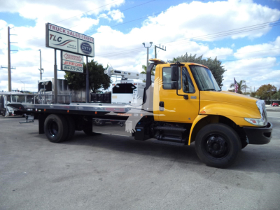 Yellow 2019 International 4300 rollback tow truck side view showing flatbed and lettering