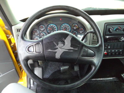 Dashboard and steering wheel of a truck with multiple gauges visible; no clear legible text readable due to watermark on steering wheel.