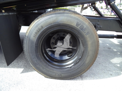 Back/side view of a wheel on a 2019 International 4300 rollback truck showing a VDL 10R22.5 tire and a decorative white goose emblem on the wheel.