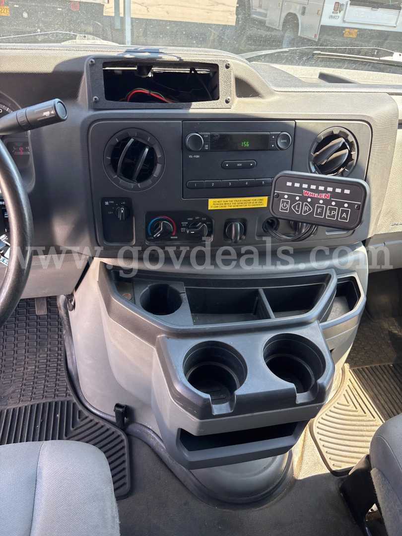 Ford Econoline cab interior showing dashboard with center controls, cup holders, and a generic keypad.