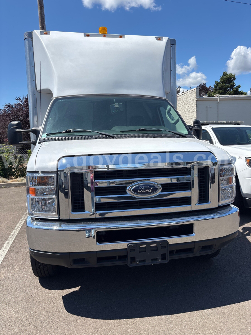 Ford Econoline box truck front view showing chrome grille, Ford emblem, headlights, and raised cargo area roof.