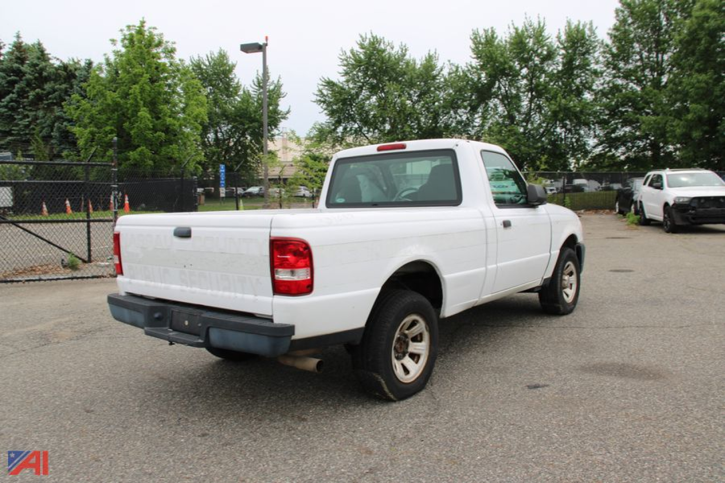 Ford Ranger pickup truck 2WD rear three-quarter view showing white body and outfitted bed in a used vehicle lot.