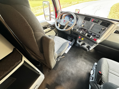 Kenworth T680 truck interior showing driver seat, steering wheel, dashboard, and center console with gauges and controls.