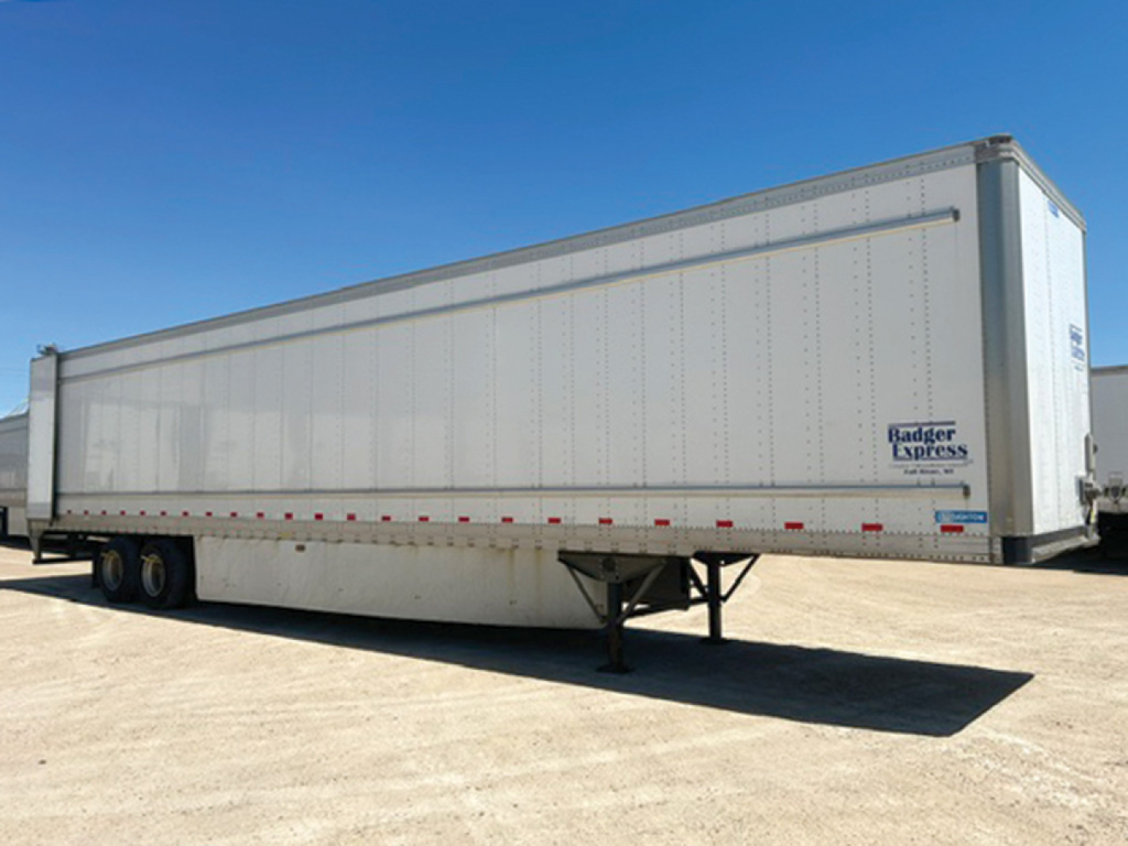 Trailer side view showing a long white Stoughton box trailer with Badger Express logo and support legs visible.