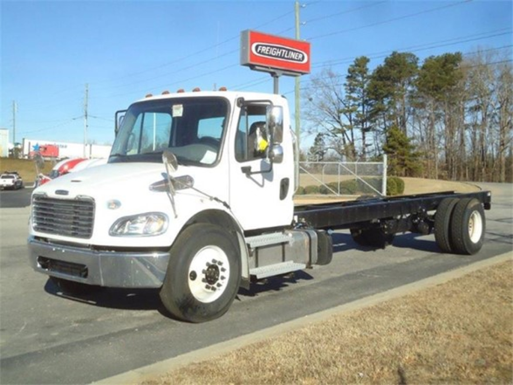Freightliner M2 106 cab and chassis truck in white with flatbed, side view showing cab and dual rear wheels.