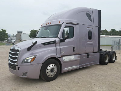 Truck side view of a purple Freightliner Cascadia126 tractor with sleeper cab, chrome grille, and dual rear axles.