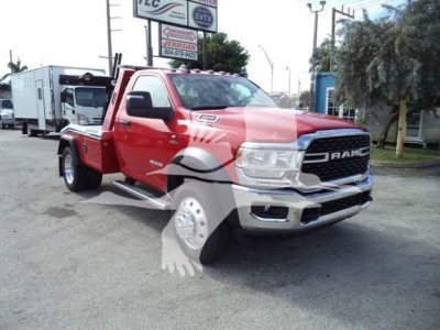 Ram 4500 tow truck in red and silver front angle showing RAM grille and tire on the front fender.