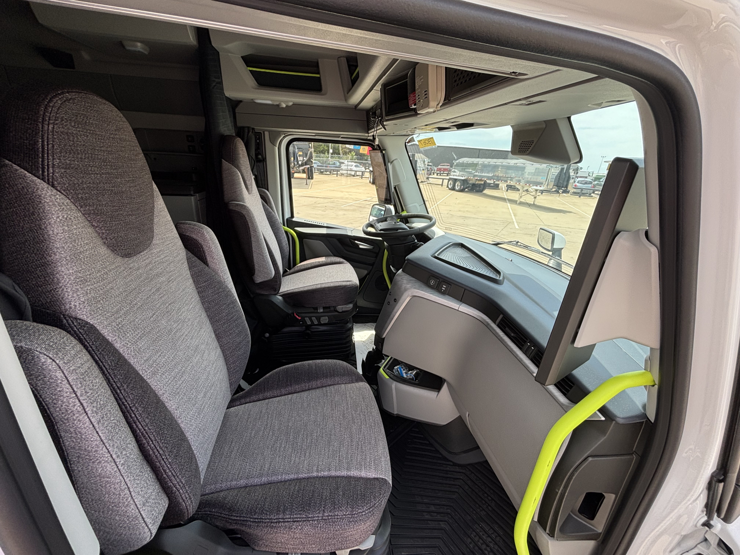 Volvo VNL64T860 cabin interior showing driver and passenger seats, dashboard, and steering wheel.