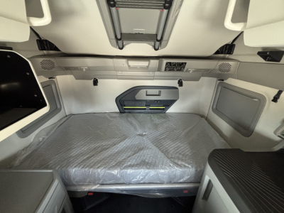 Volvo VNL64T860 sleeper cab interior showing sleeping area with mattress and overhead storage panels.