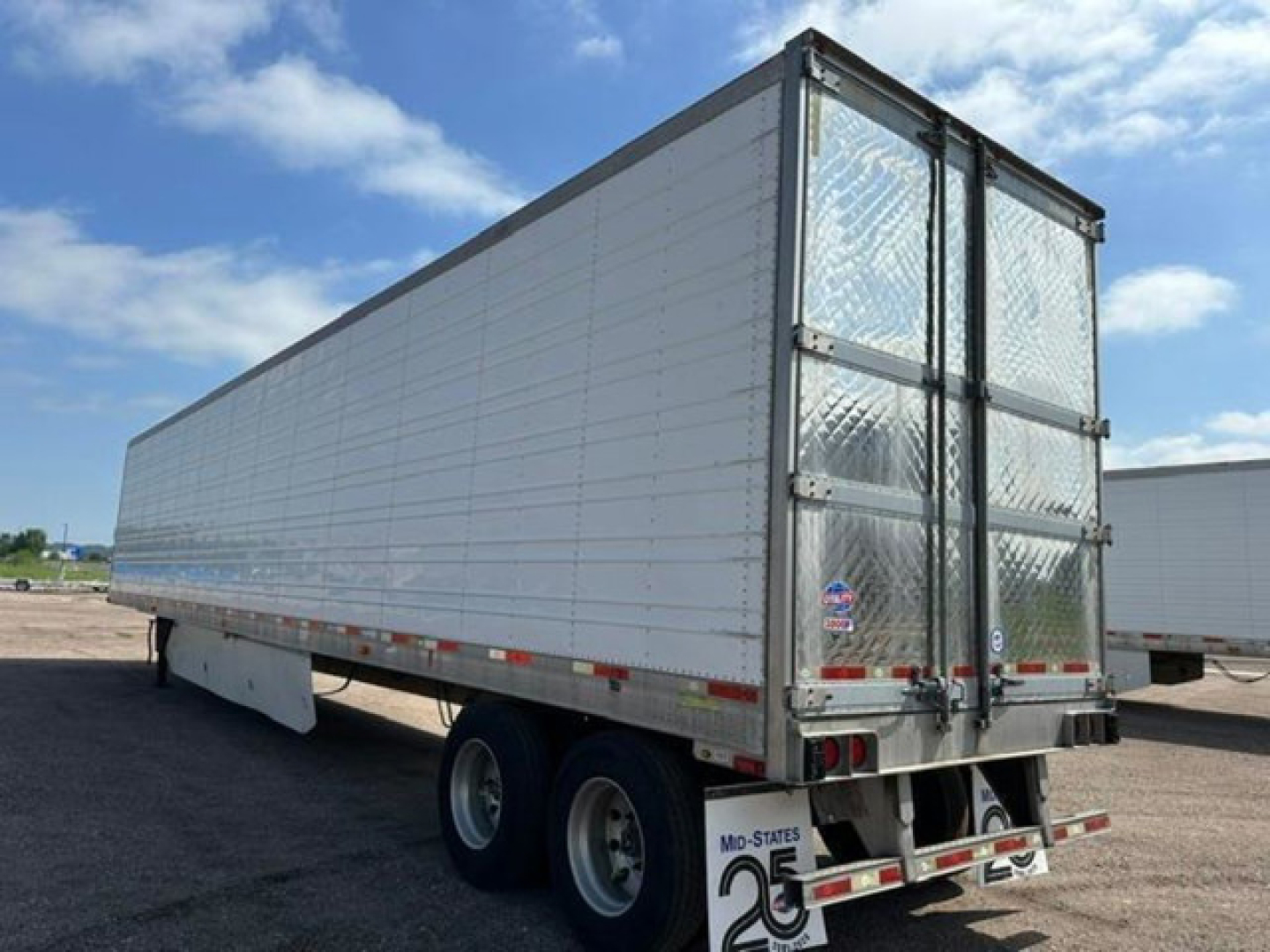 Trailer side and rear showing a 2016 refrigerated utility trailer with silver aluminum sides and a diamond plate rear door.