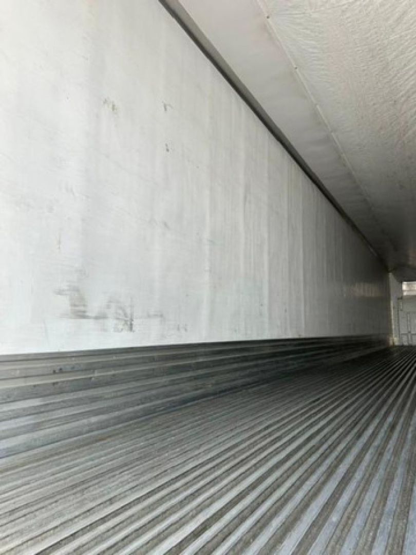 Trailer interior cargo bay of a 2016 utility reefer showing ribbed metal floor and smooth side walls.