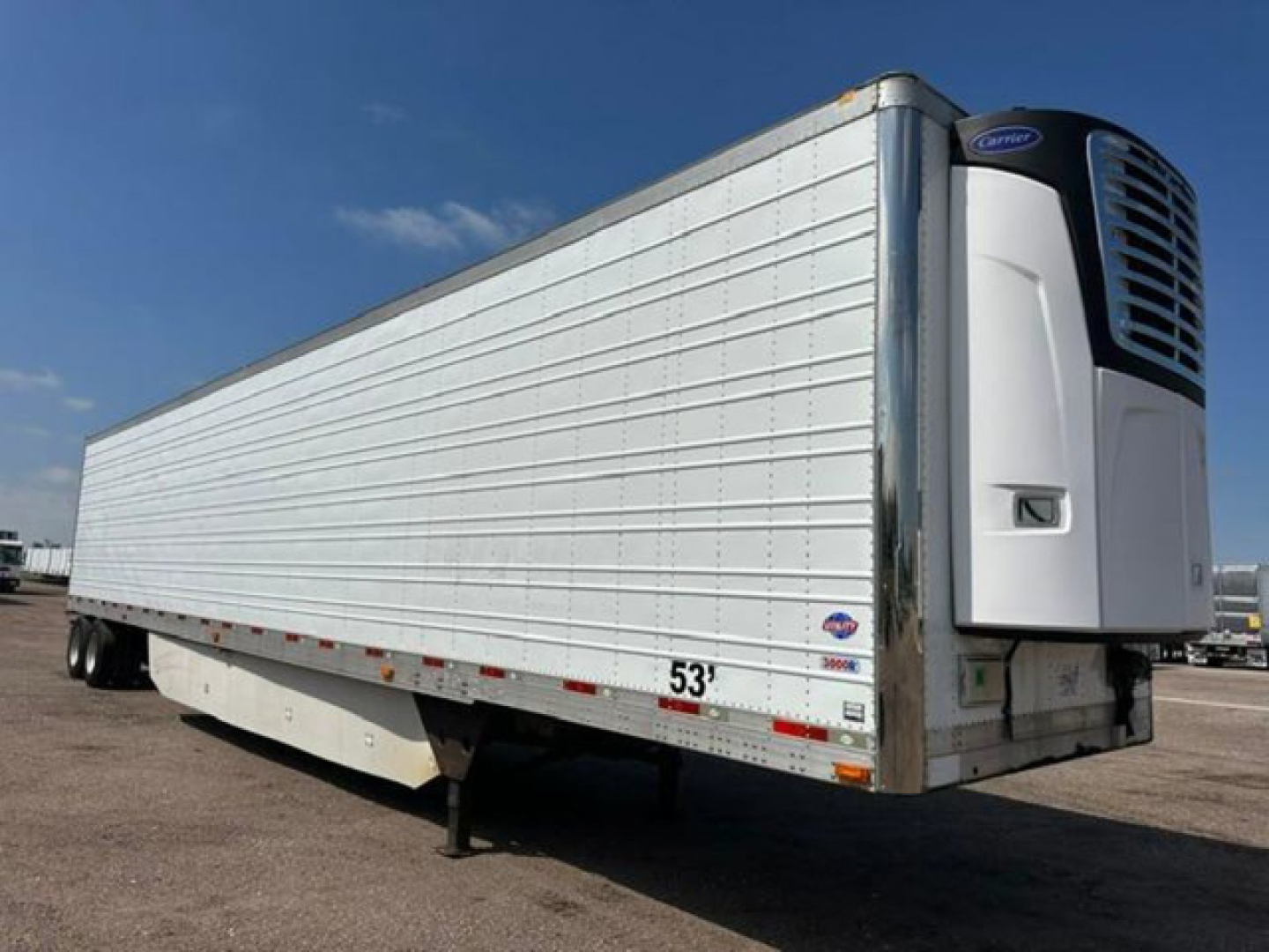 Trailer side view showing refrigerated utility trailer with Thermo King unit on front, metal ribbed sides, 53' length, stock U90983, VIN 1UYVS2535GU494818.