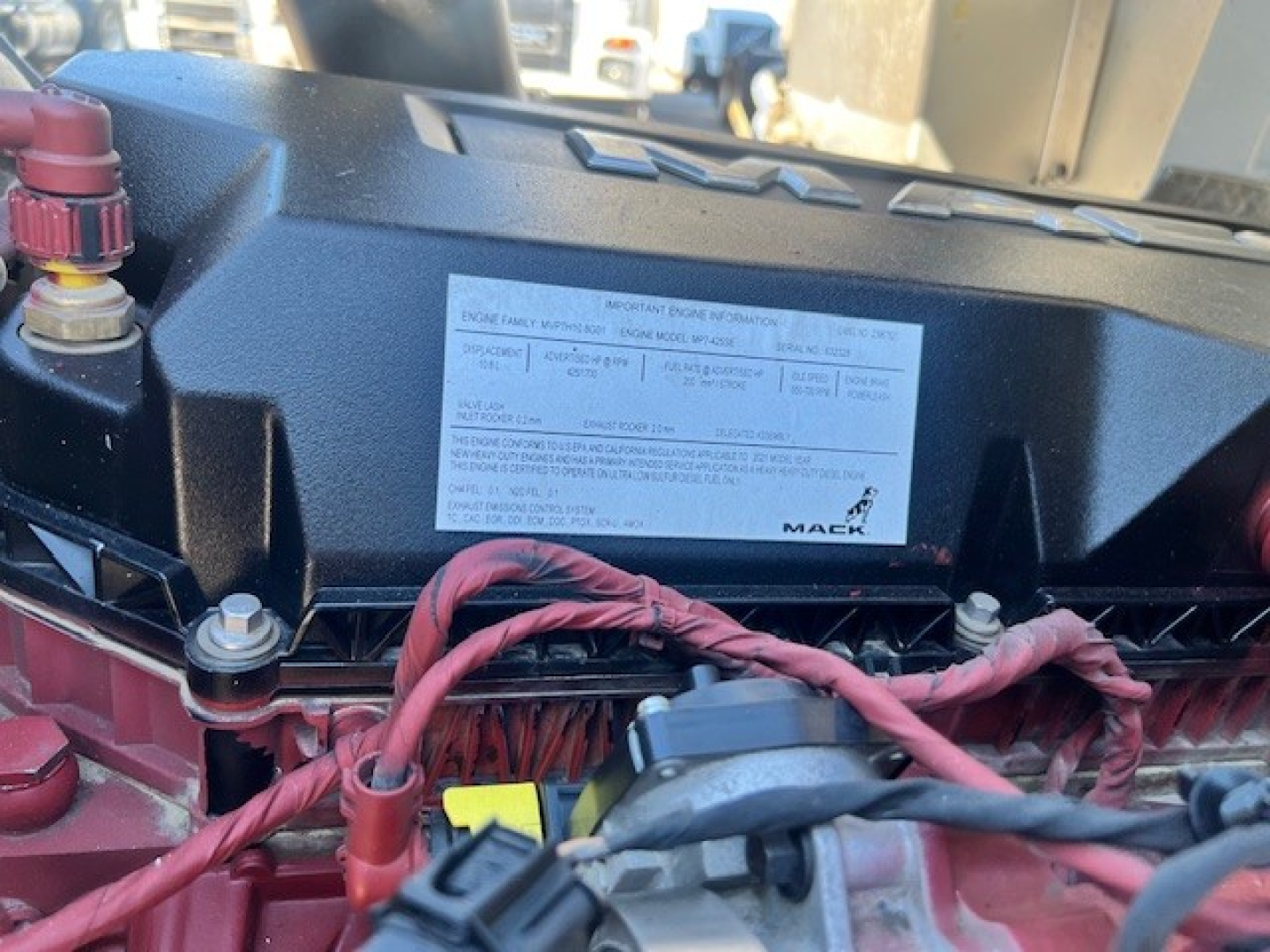 Mack AN42T truck engine bay showing label with specifications and red braided wiring harnesses.