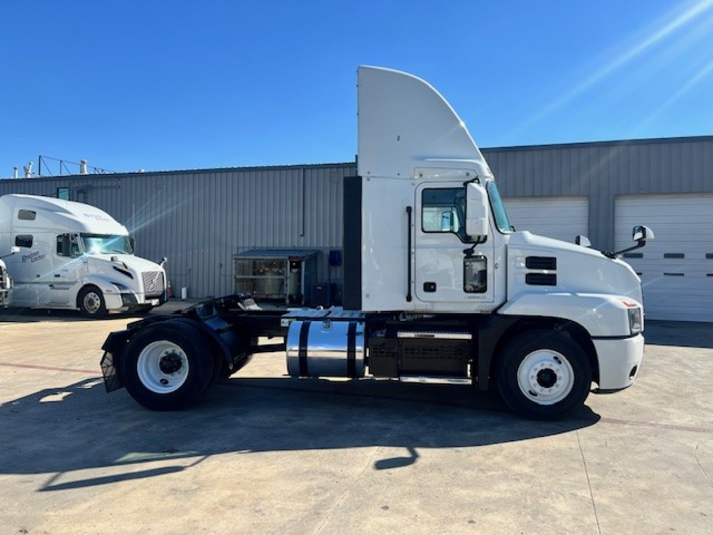 Truck side view of a 2022 Mack AN42T daycab with white cab, fuel tanks, chassis, and large sleeper/roof fairing; no visible text on livery.