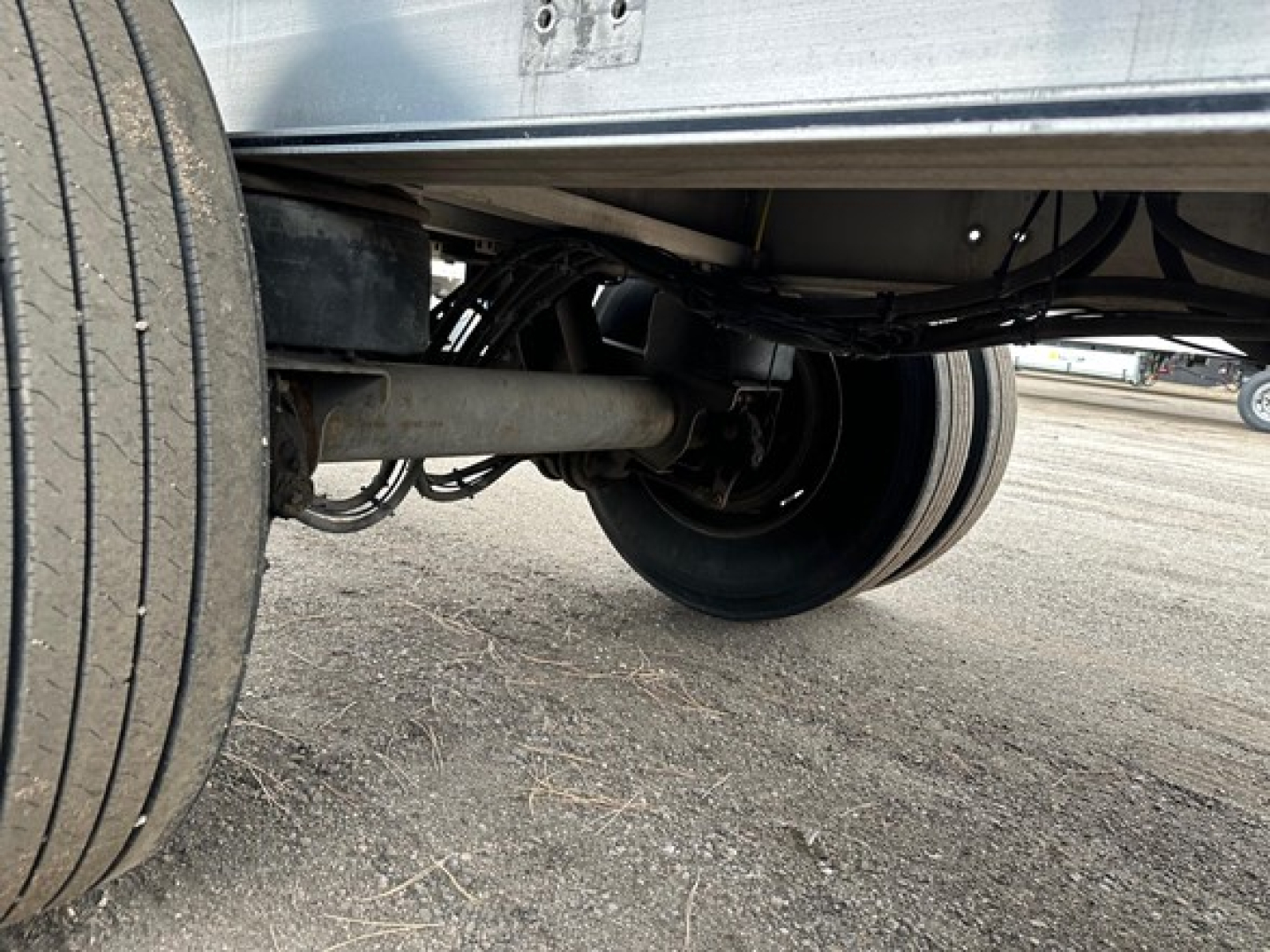 Trailer undercarriage showing dual rear wheels and axle assembly of a 2018 Mac aluminum flatbed trailer.