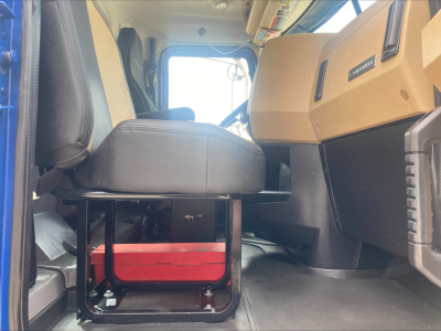 Cab interior of a 2019 Mack GR64F roll-off truck showing driver's seat and dashboard area.