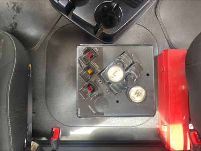 Control panel with switches and gauges on Mack GR64F roll-off truck cab floor showing engine start/stop switch and indicator labels.