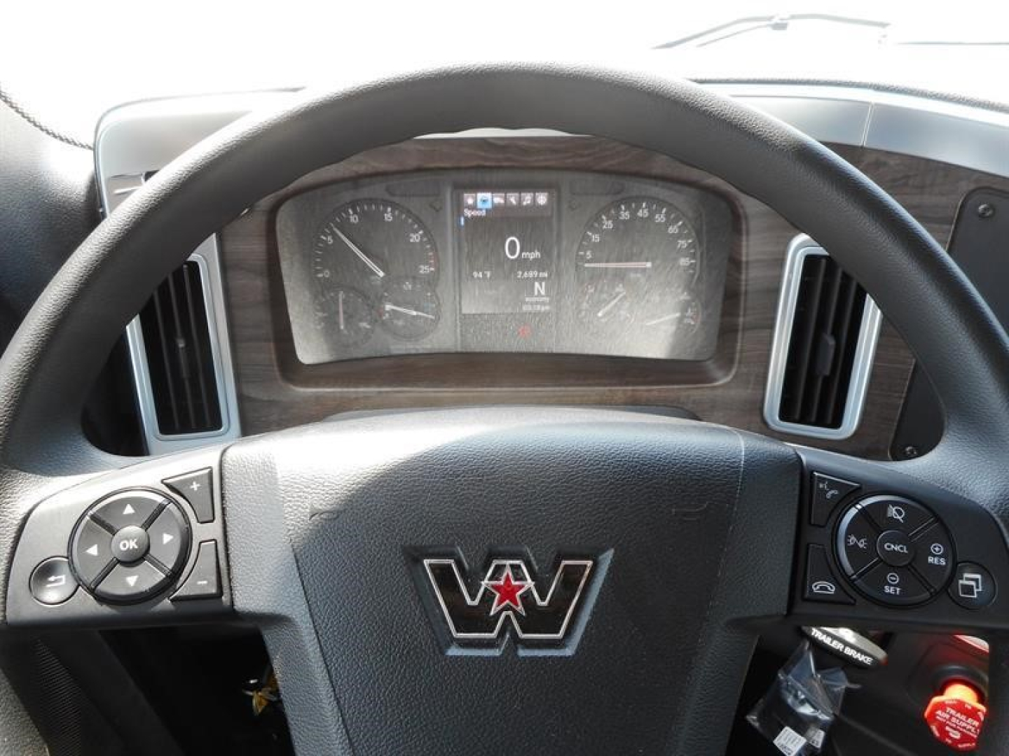 Western Star 49X interior dashboard view from driver seat showing steering wheel with Western Star logo, instrument cluster, and control stalks.
