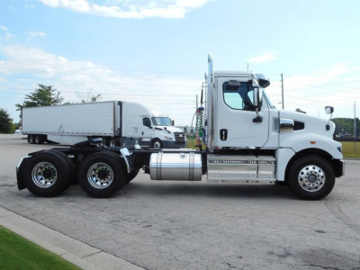 Western Star 49X day cab tractor in profile view showing chrome fuel tanks and dual rear axles.