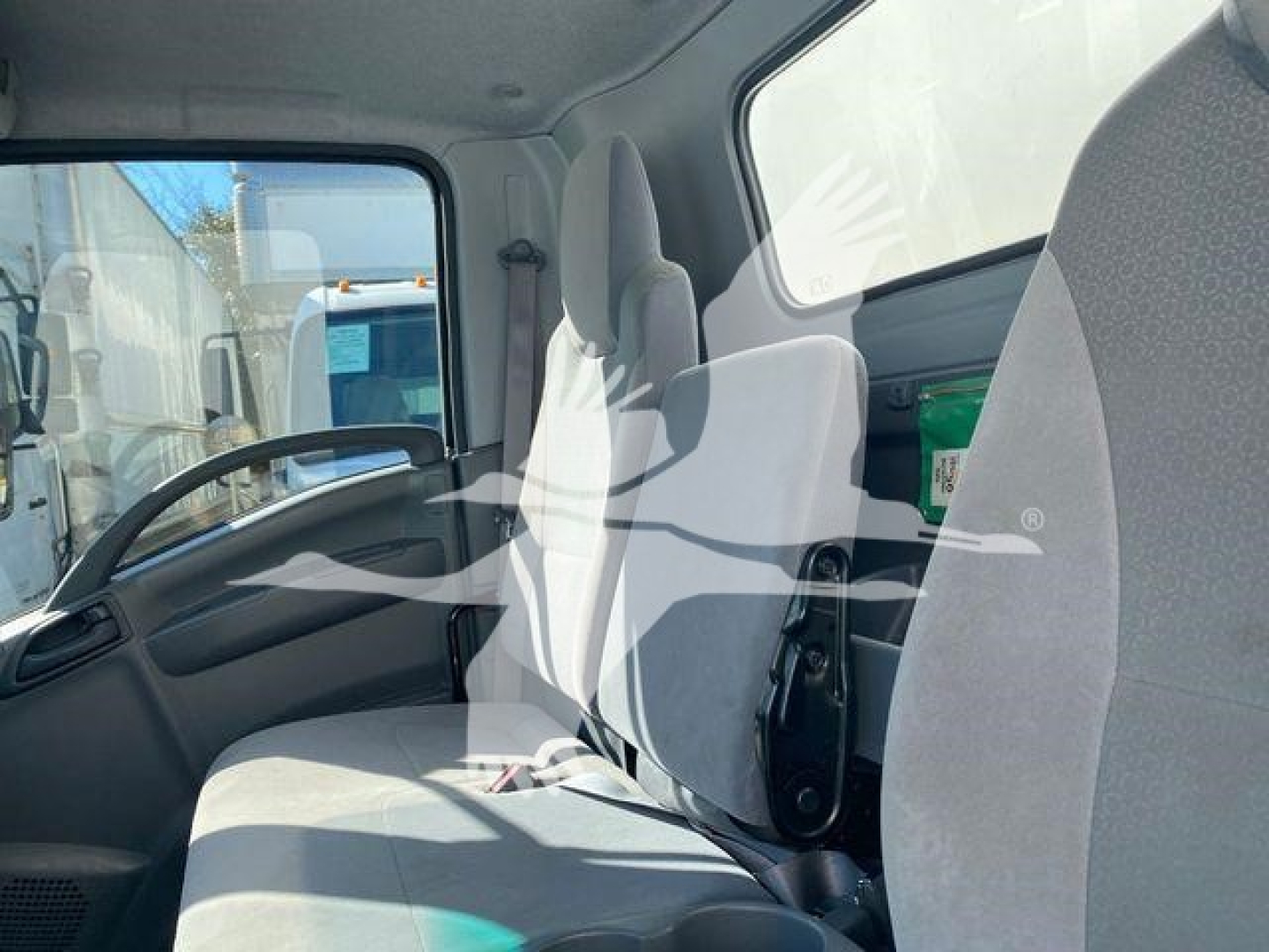 Isuzu NQR truck cabin interior with front seats and steering wheel visible.