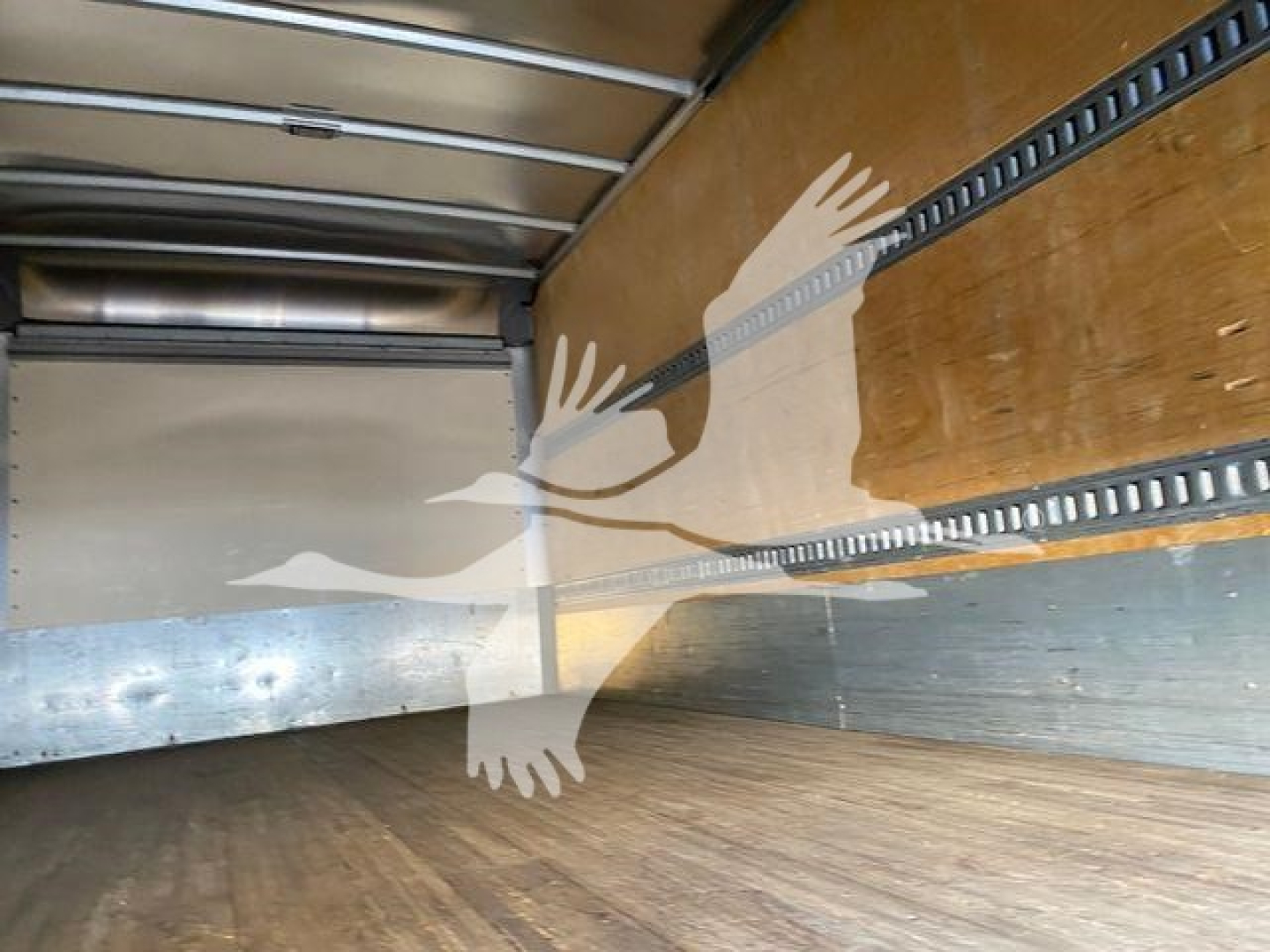 Isuzu NQR truck cargo area interior with metal side rails and wooden floor, empty trailer