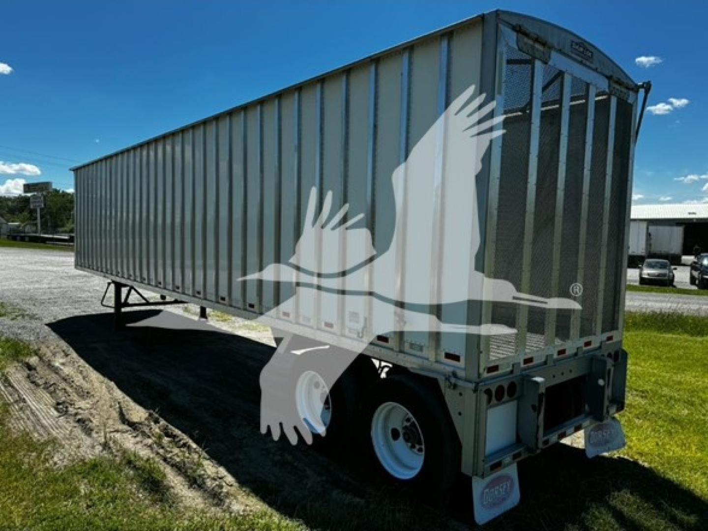 Open-top chip van trailer showing side and rear with Dorsey branding on container and dual rear wheels.