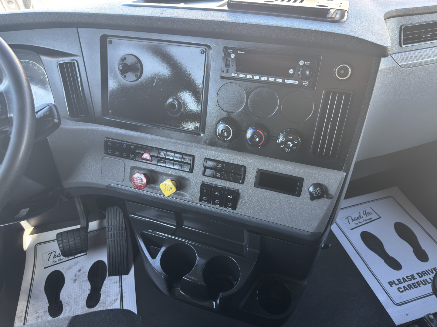 Freightliner Cascadia truck dash showing control panel and cup holders
