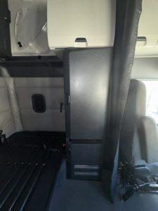 Cab interior of a 2022 Freightliner Cascadia 126 showing cabin partition and driver seat area.