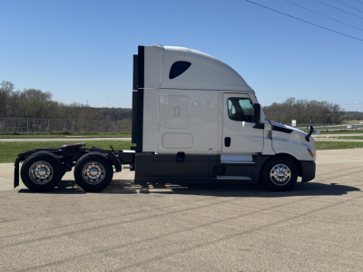 Freightliner Cascadia 126 tractor unit side view showing sleeper cab and chassis with dual rear axles and standard wheels.