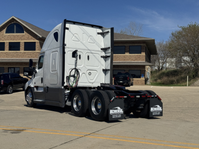 Freightliner Cascadia 126 tractor in a lot showing rear and side, with rear wheels and fifth wheel; some text on mud flaps and back of cab; no legible brand labels visible on side panels.