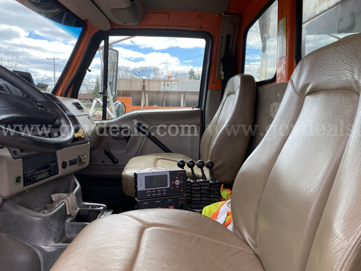 Cab interior of a 2005 Sterling L9500 dump truck showing driver and passenger seats, dashboard, gear shifter, and control console.