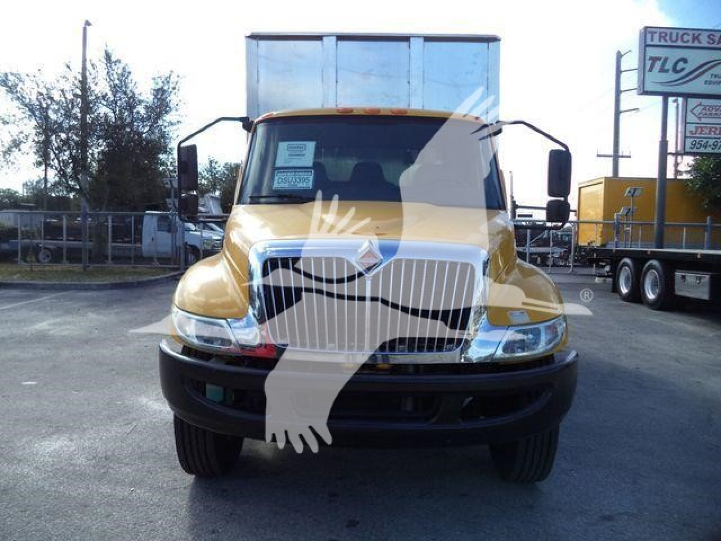 Truck nose of a 2019 International 4300 with yellow paint, front grille, headlights, and mirrors visible.