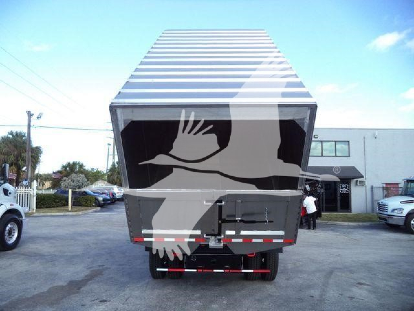 Truck rear with large cargo container open top showing hitch and rear bumper; no legible text visible.