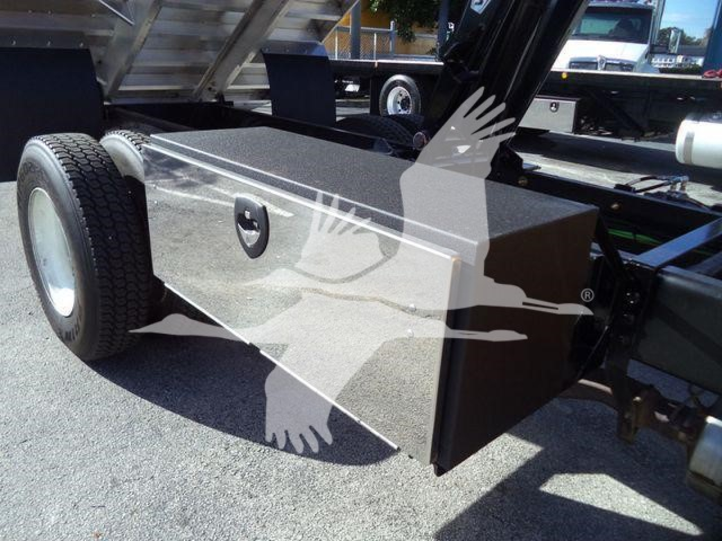 Storage toolbox mounted on trailer frame with wheel and chassis components visible