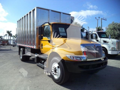Truck cab and cargo box of a 2019 International 4300 medium-duty truck with yellow cab and silver box, front grille and headlights visible, stocky wheel setup.