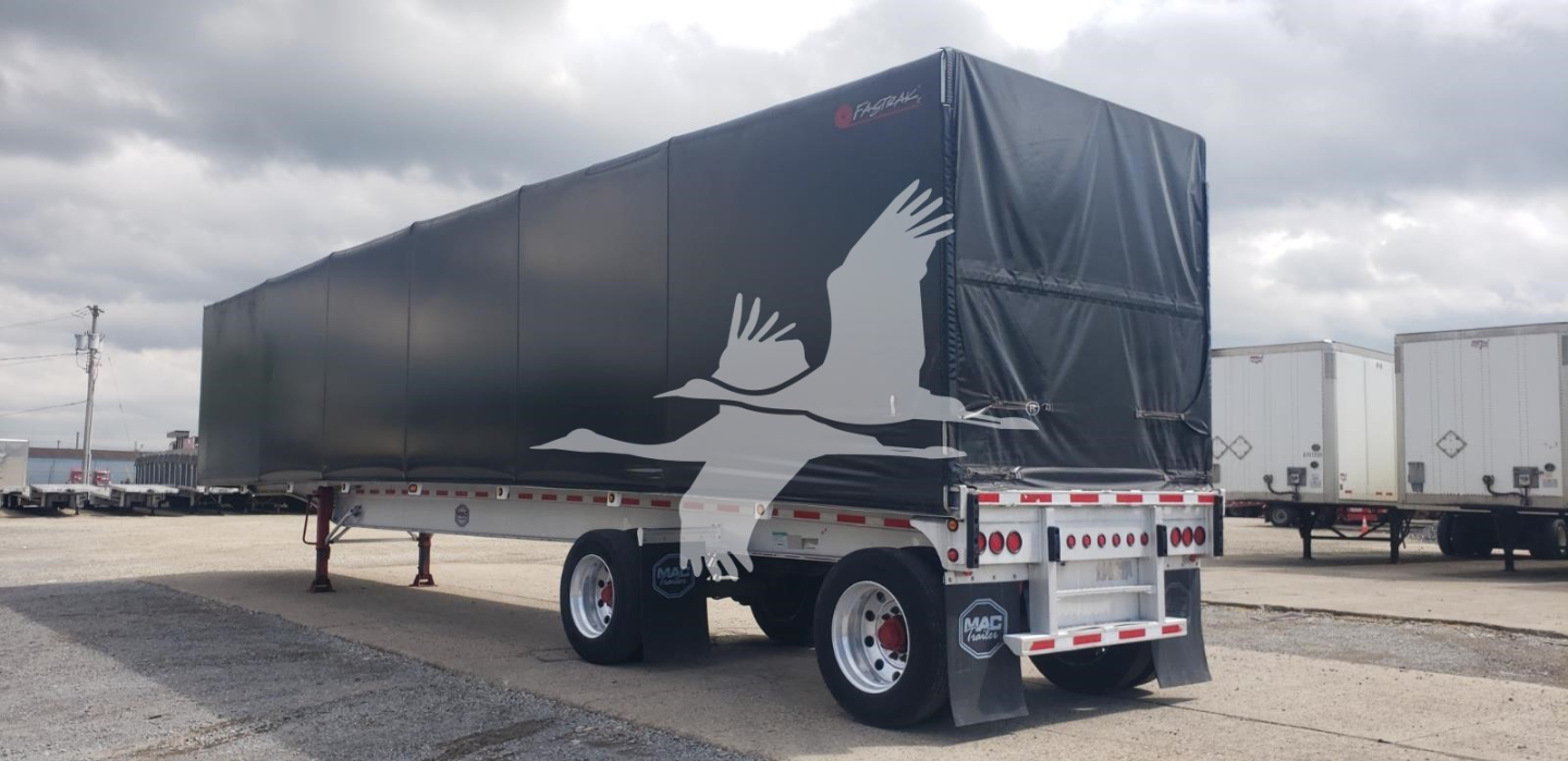 Trailer showing a curtain side with a large white eagle graphic and rear lights.