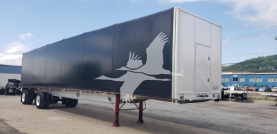 Trailer showing side graphics of two cranes on a curtain side with white rear door; text not visible.