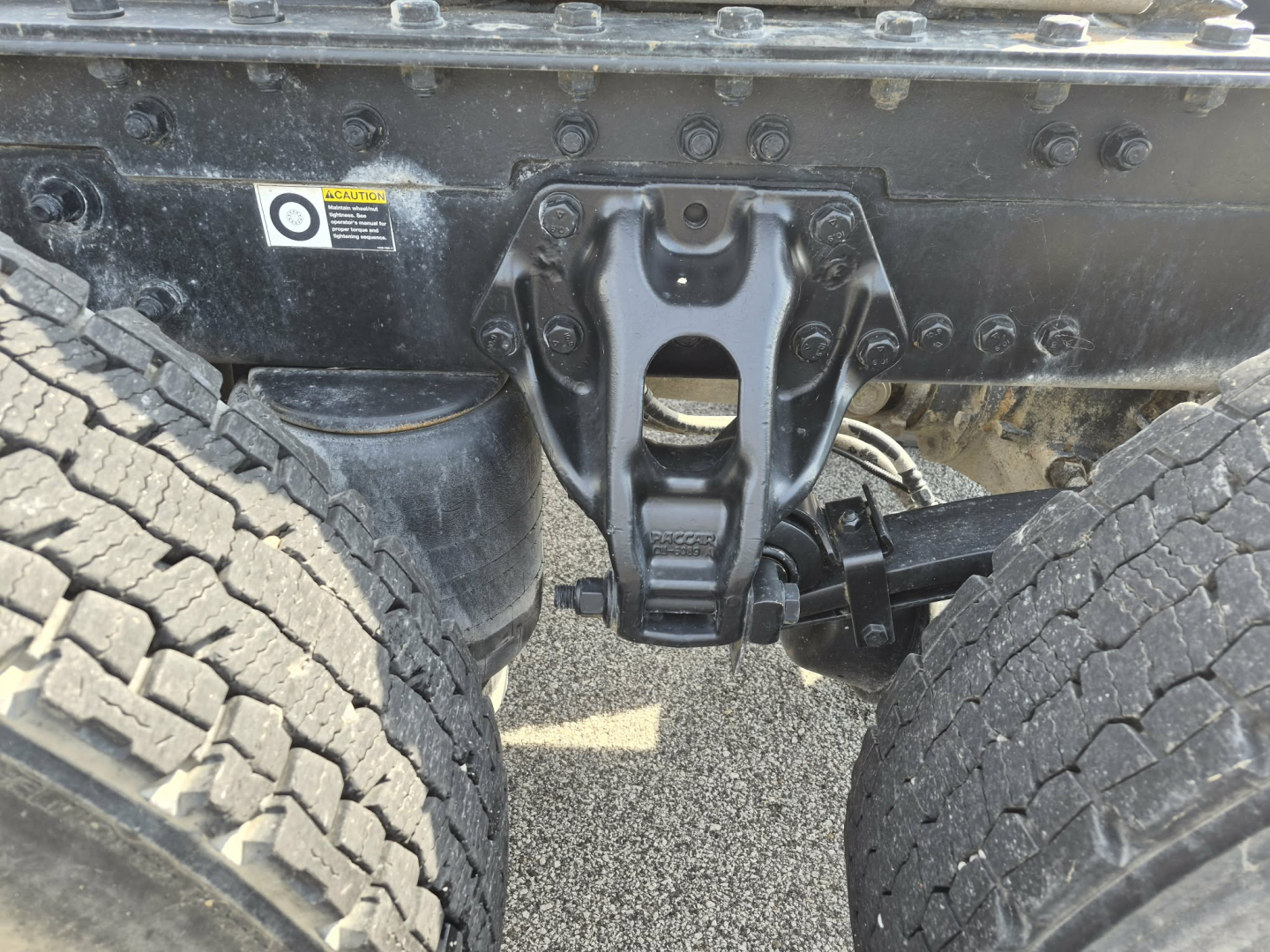 Kenworth T880 chassis showing fifth wheel hitch and dual rear tires, undercarriage components and frame crossmember.
