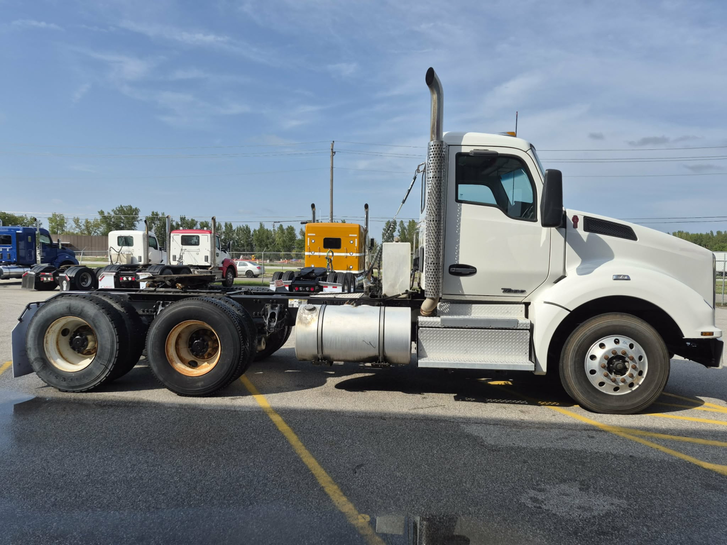 Kenworth T880 conventional daycab truck side view showing cab, fuel tanks, and rear frame without a trailer.