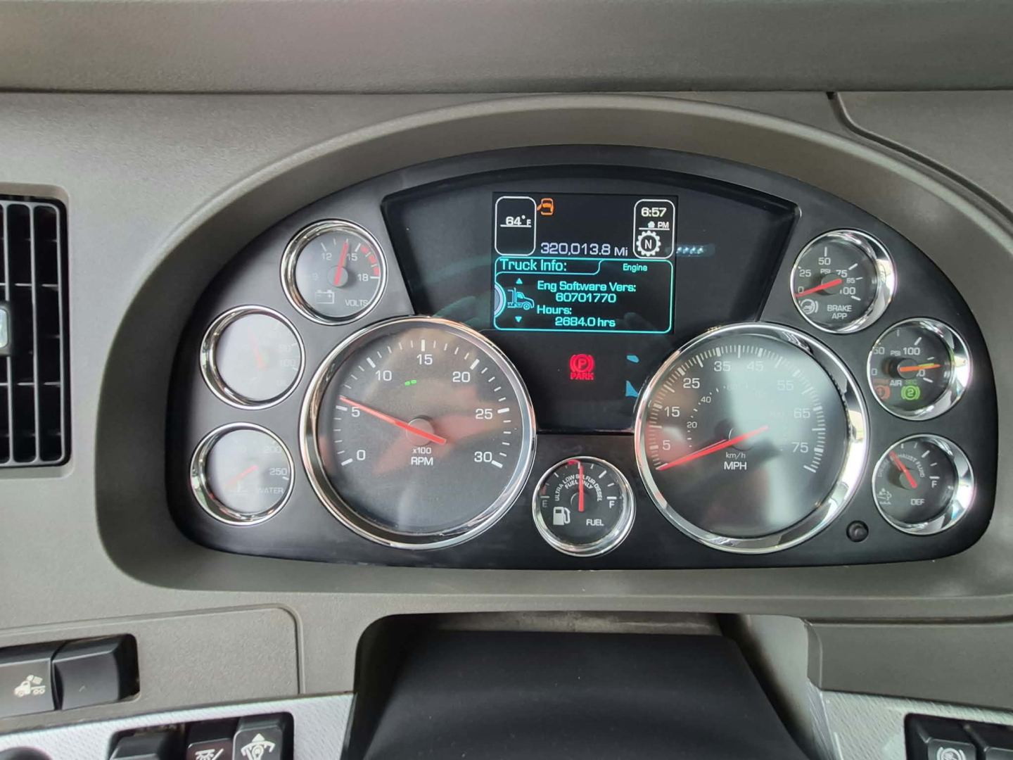 Dashboard cluster of a Kenworth T880 showing multiple gauges and a central digital display with mileage readout.