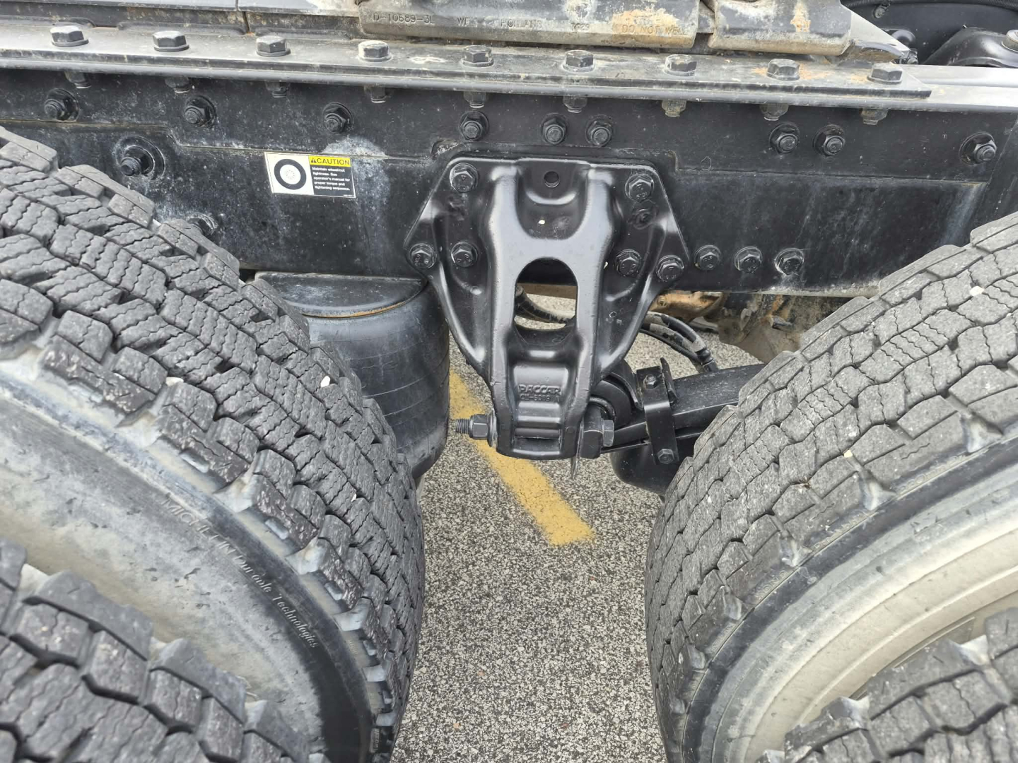 Kenworth T880 chassis center section showing rear dual tires and suspension/componentry with VIN/stock details not visible. Image focuses on driveline near axle