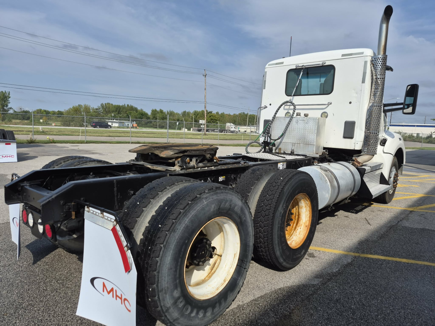 Kenworth T880 tractor with fifth wheel removed showing rear dual axle on highway lot.