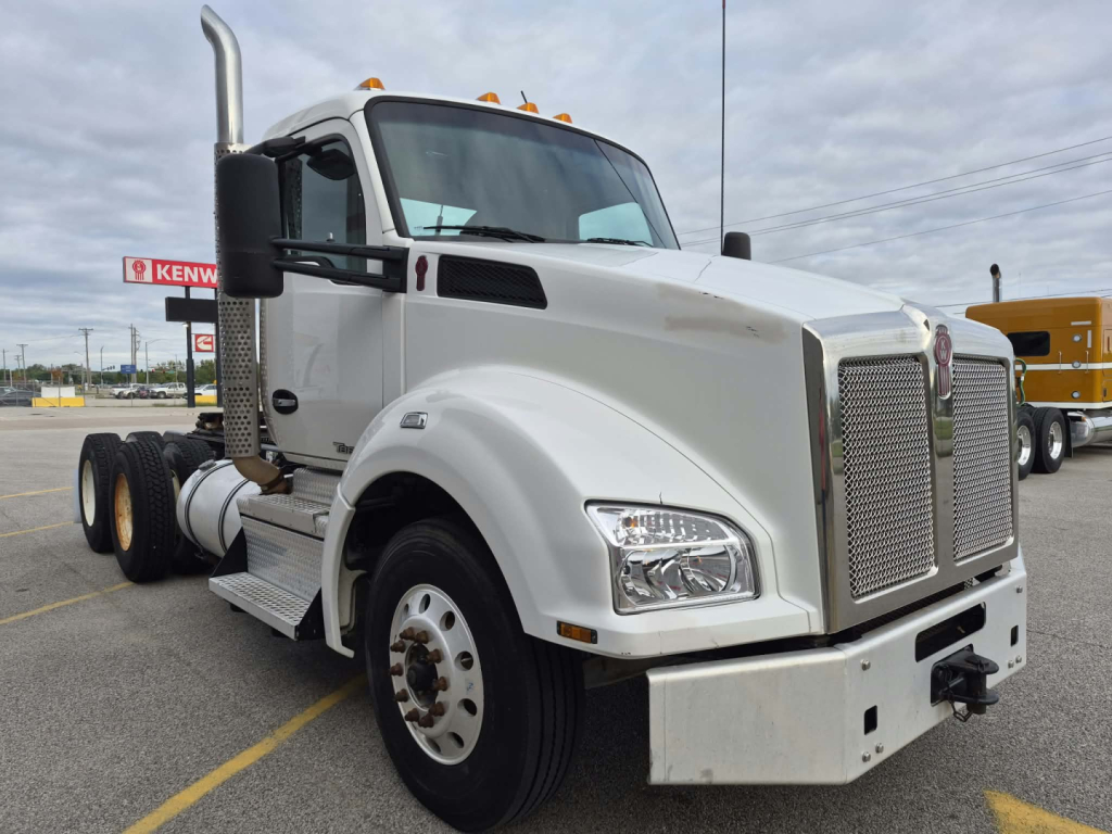 Kenworth T880 conventional daycab truck side view showing front grille, chrome bumper, large headlights, dual rear axles, and fuel tanks.