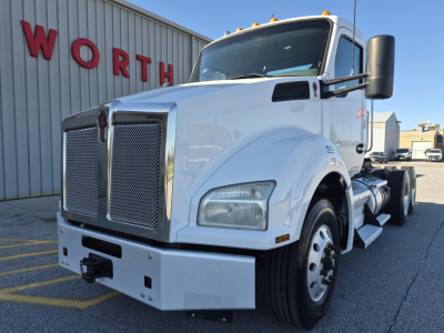 Kenworth T880 conventional day cab truck in white, front-left view, showing large grille, bumper, headlights, and side steps.